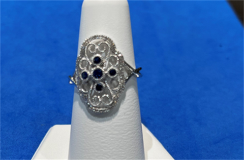 white gold ring with sapphires on white showcase finger