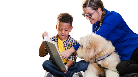 African American boy reading to a Therapy dog