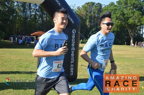 Amazing Race of two Asians running with blue shirts on